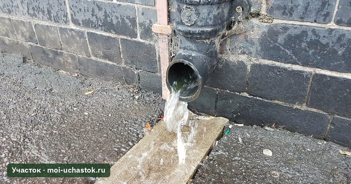 Водосточная труба с лотком у стены дома
