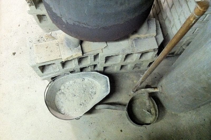Совок с древесной золой из печи