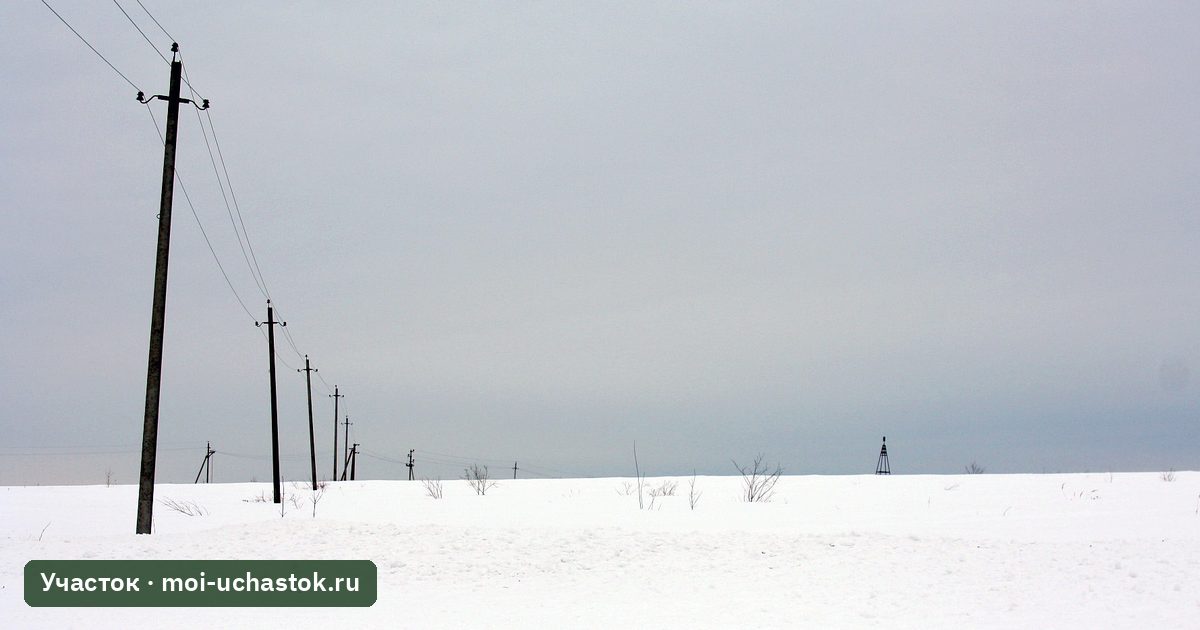 Опоры линии электропередачи в заснеженном поле